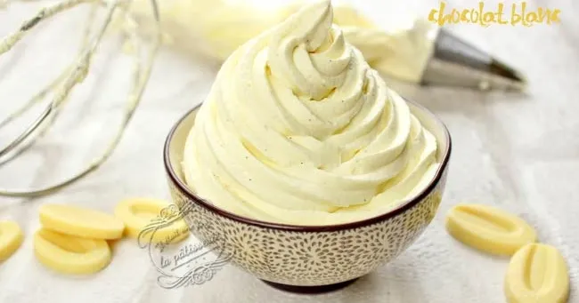 Bol contenant une ganache au chocolat blanc onctueuse, spatule recouverte de crème, tablette de chocolat blanc cassée et